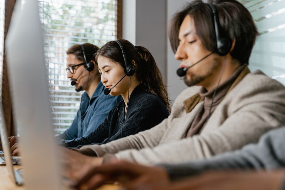 Call centre agents with headsets at their desks
