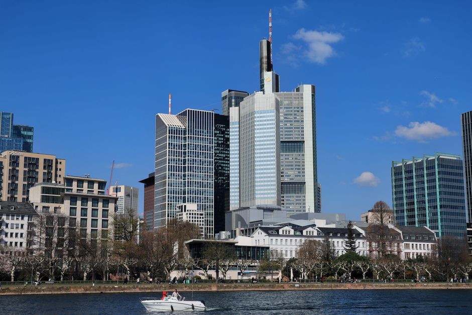 A financial-district skyline above a river on a clear day